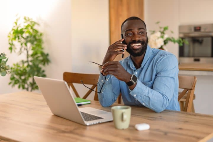 Happy freelancer talking on the phone and working from home