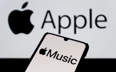In this photo illustration, the Apple Music logo is seen displayed on a smartphone with an Apple logo in the background.